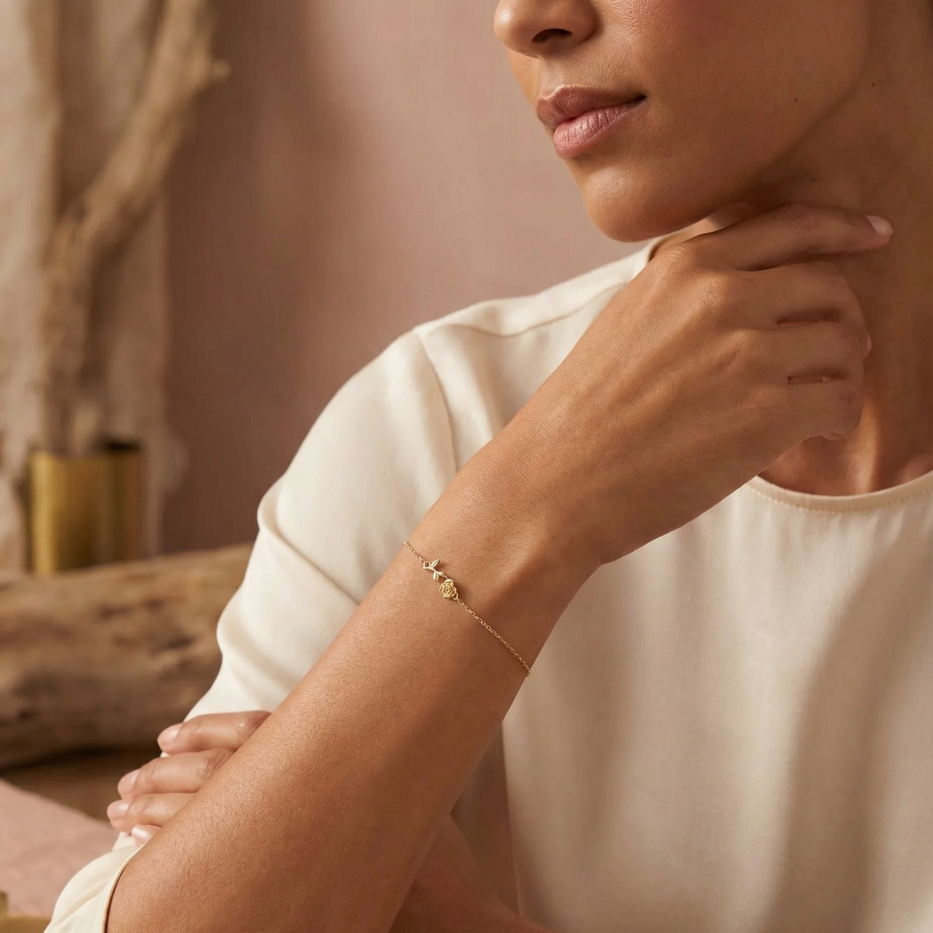 Woman wearing a gold rose bracelet on a blurred indoor background